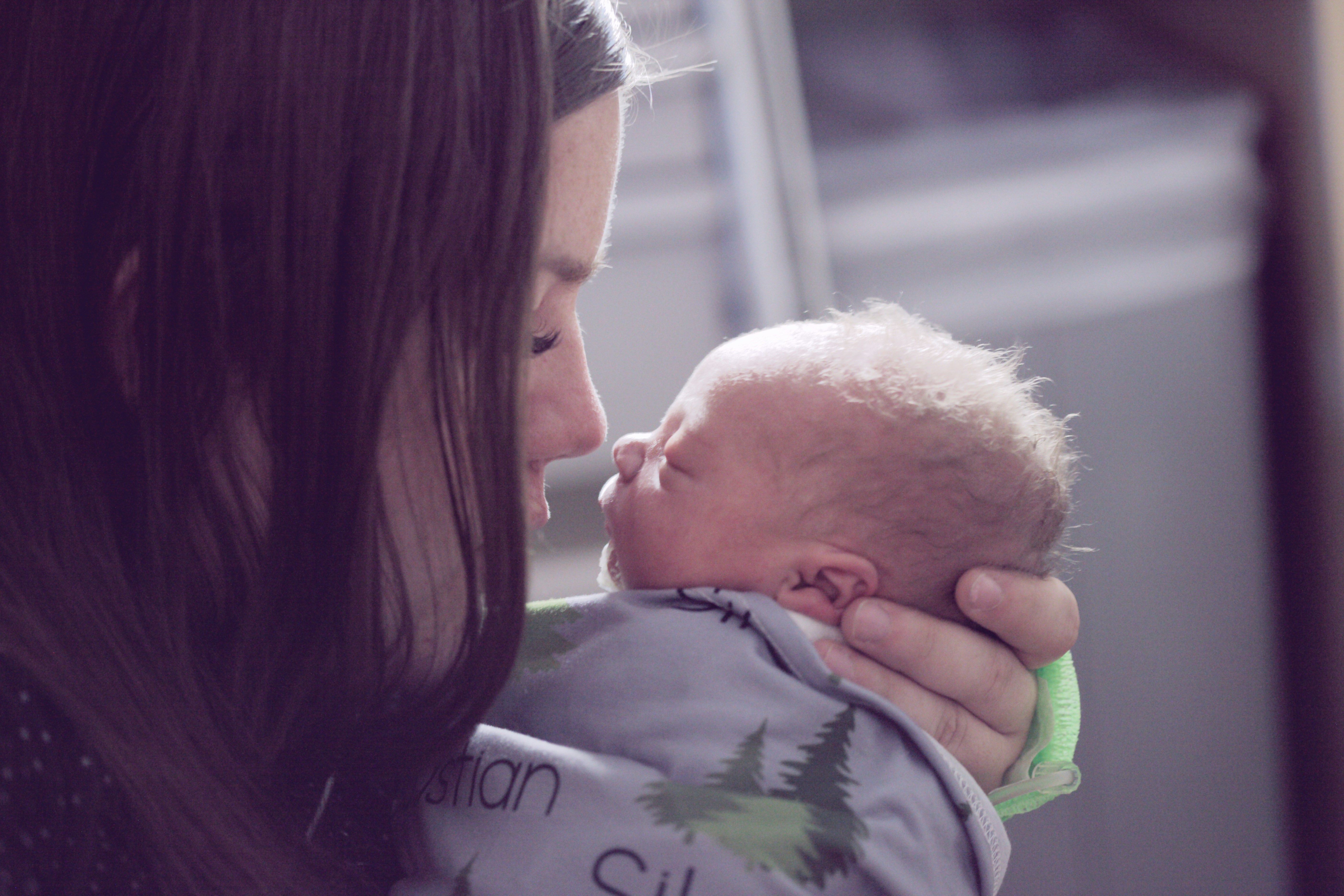 A new mother sitting quietly with her baby, taking a breath in a moment of calm
