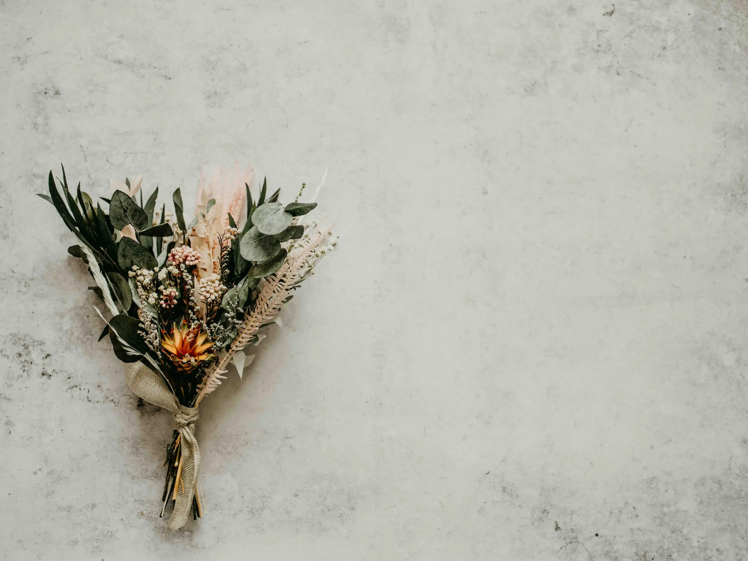 a solemn bouquet of wildflowers on a mostly white background