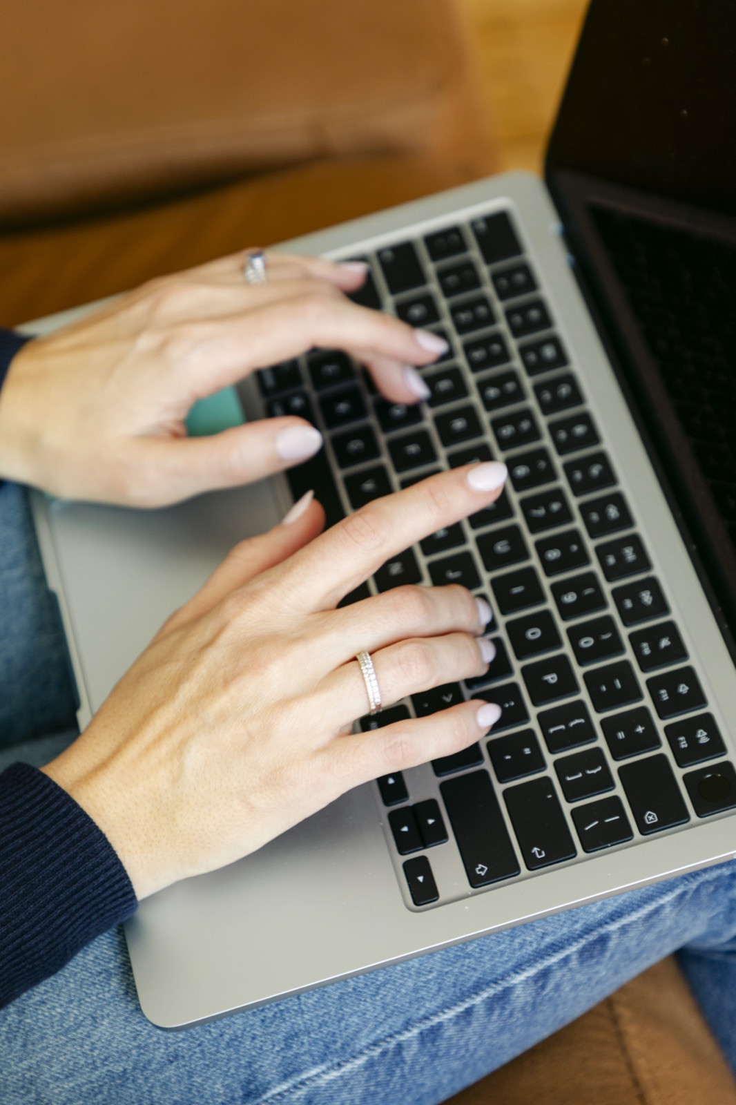 Hands typing on a laptop keyboard